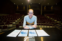 A student in front of a large music hall